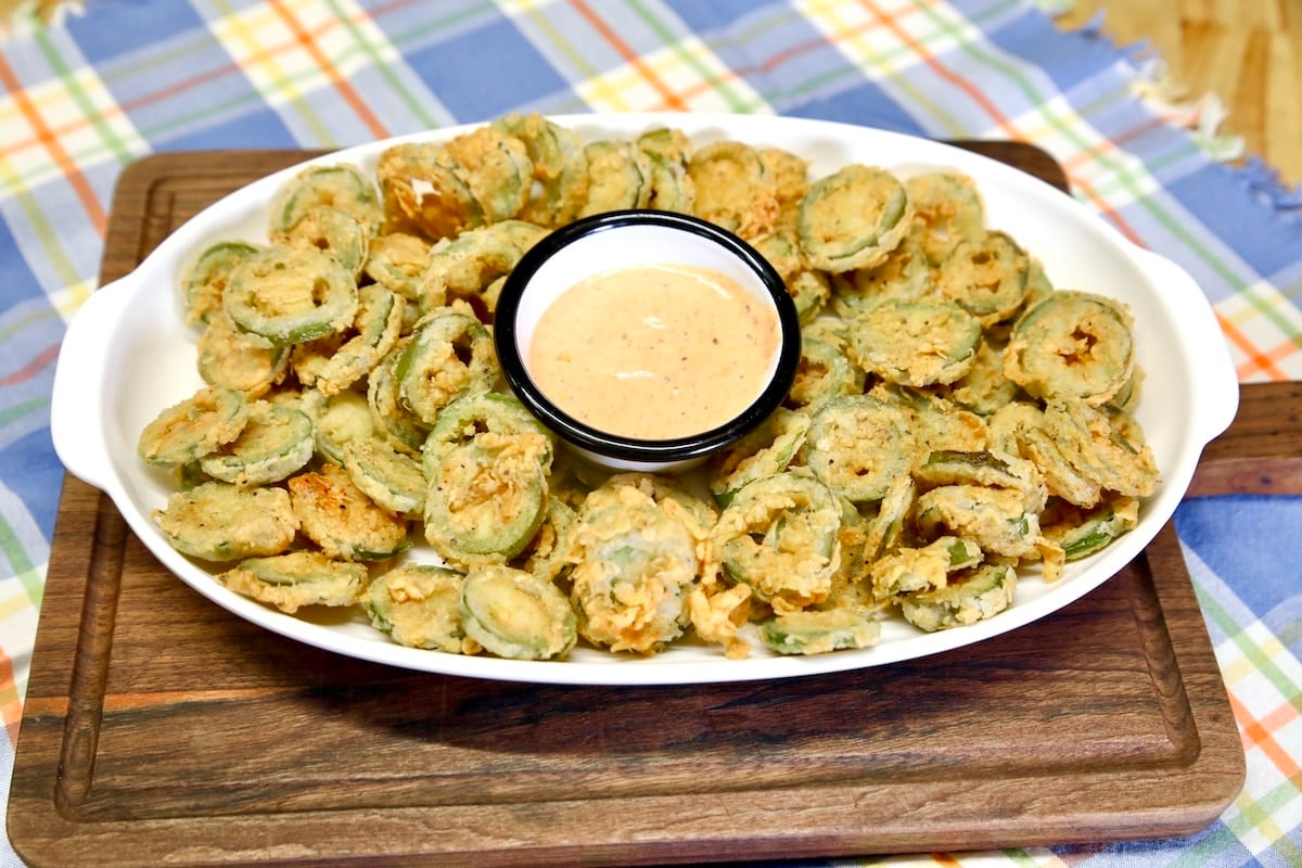 Platter of fried jalapenos with cup of dipping sauce.