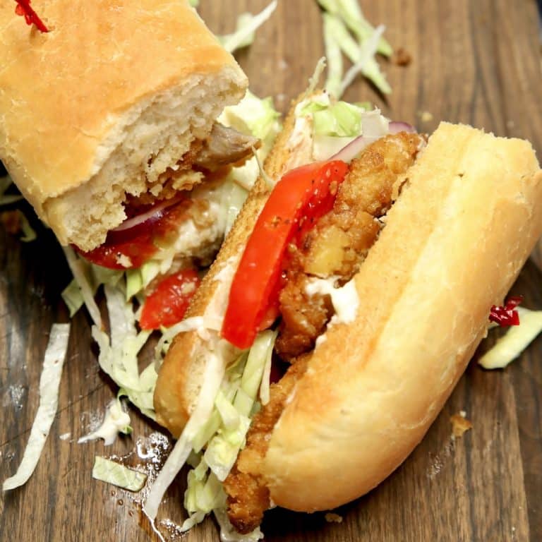 Pork chop sandwich on a hoagie bun, cut in half.