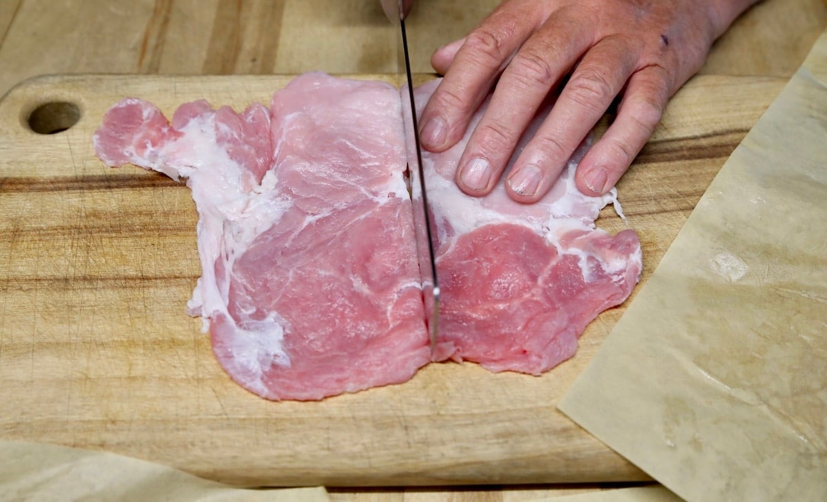 Pork Chops cutting in half on a board.