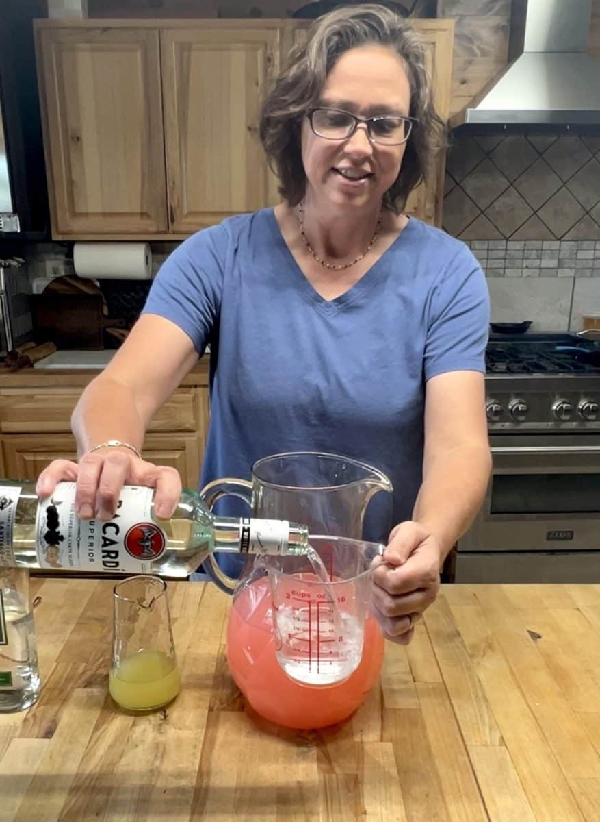 Pouring rum into measuring cup.