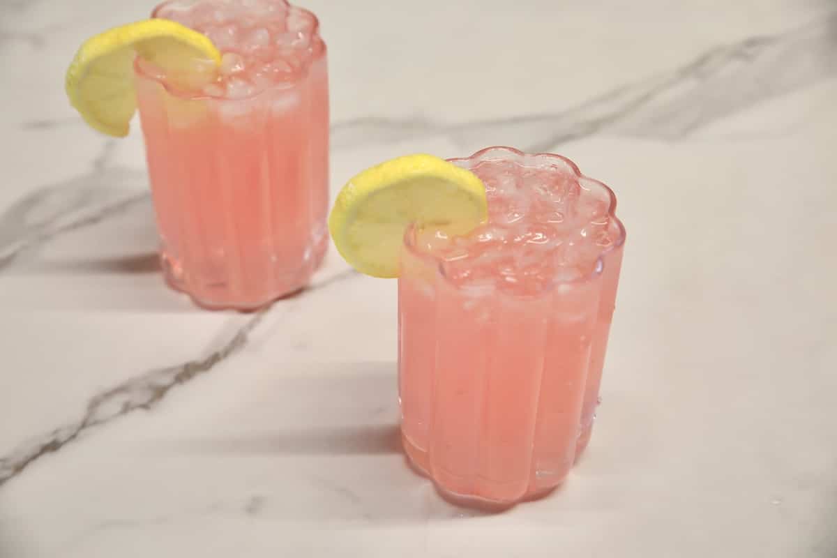 Hippie Juice cocktail in 2 glasses with lemon slice garnish.