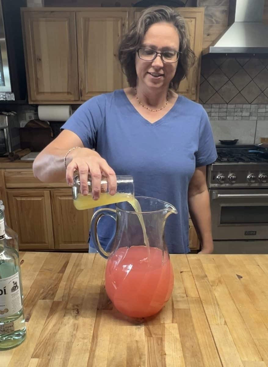 Adding pineapple juice to pitcher.
