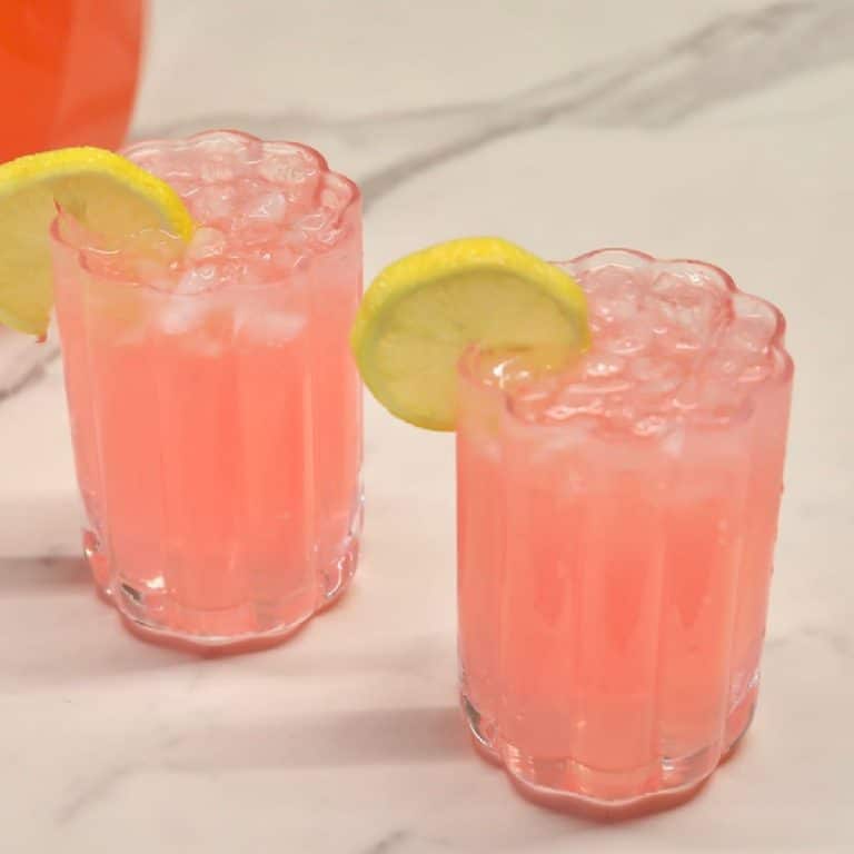Pink punch in 2 glasses with lemon garnish.
