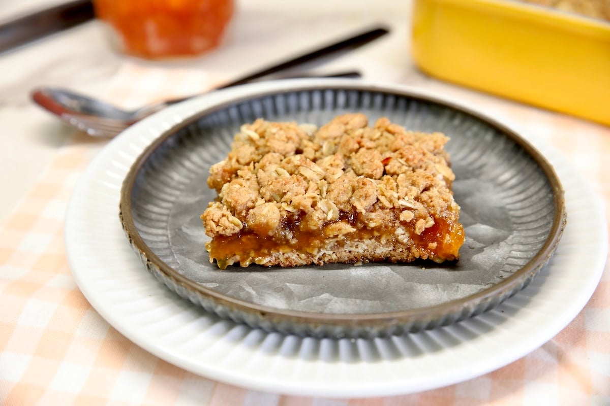Peach bars with oatmeal cookie crumble. Peach oatmeal bar on a plate.