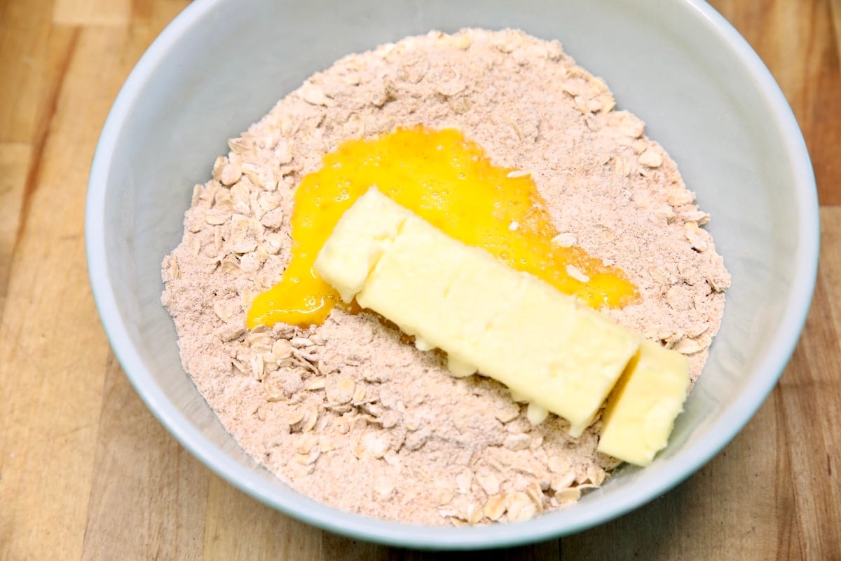 Butter and egg in a bowl of oat crumble.