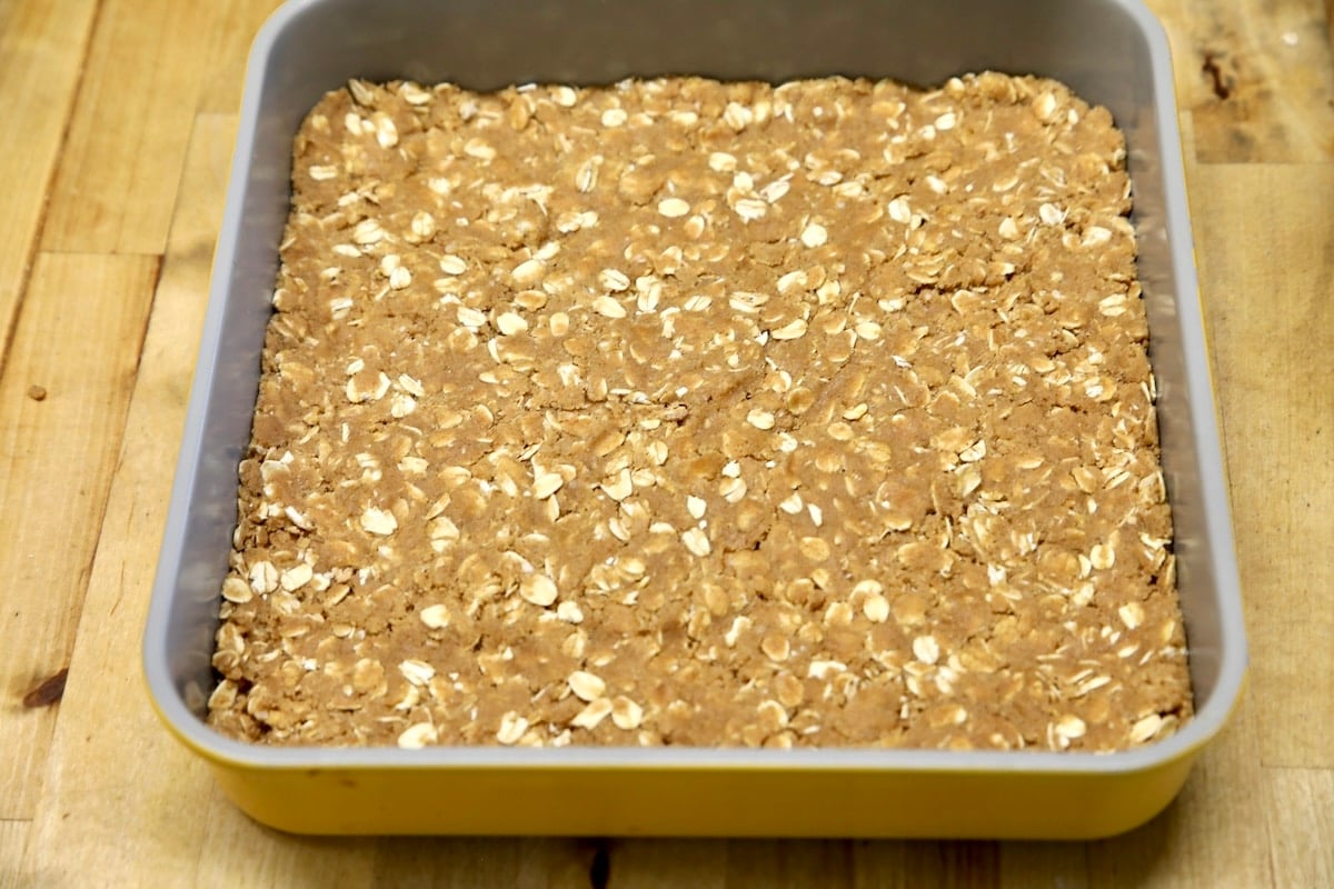 Oatmeal cookie crust in square pan.