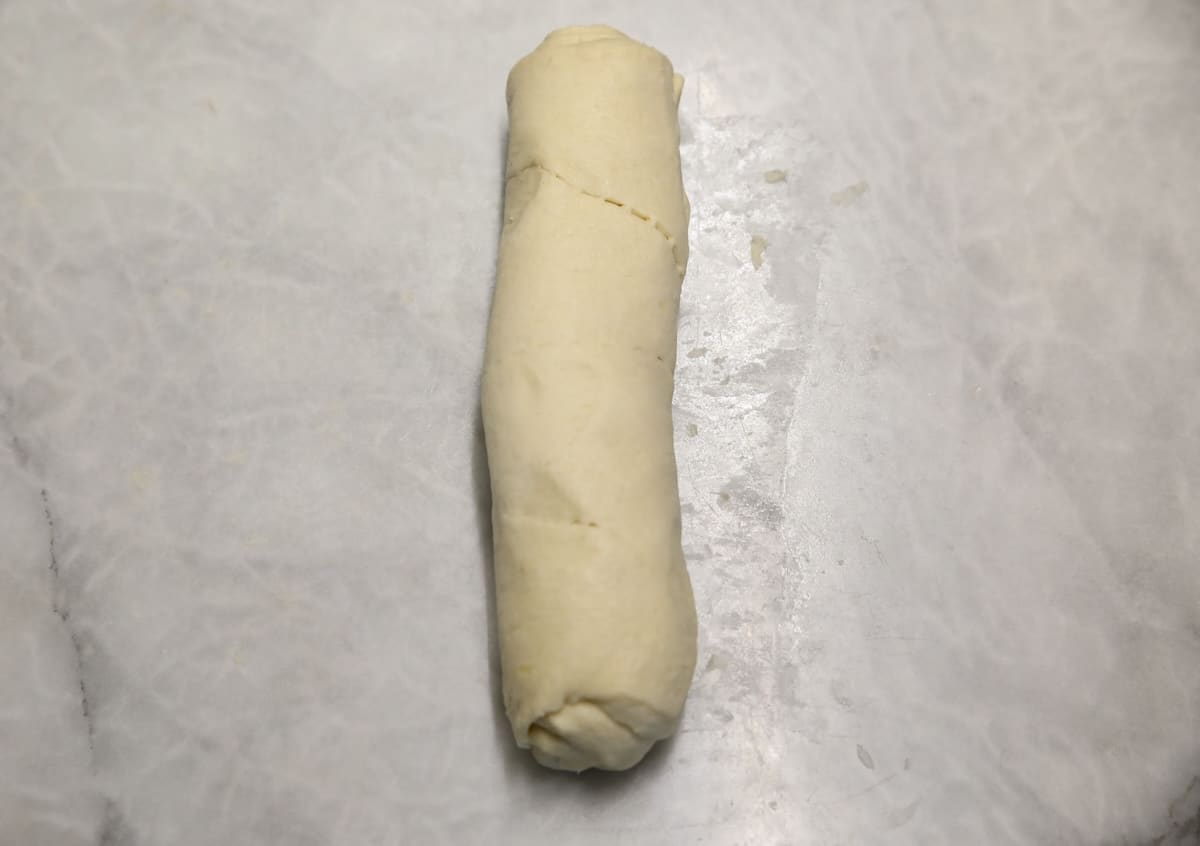 Crescent dough rolled up like cinnamon roll log.
