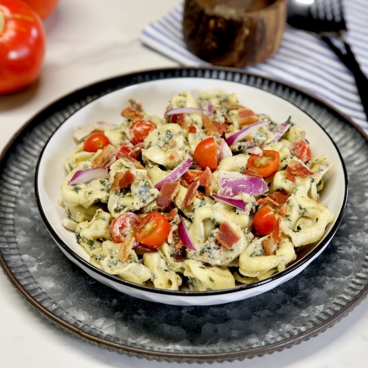 Tortellini Pasta salad in a bowl with bacon and tomatoes.