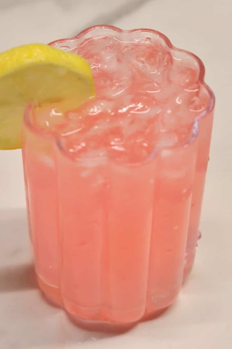 Hippie juice cocktail in a glass with lemon slice.