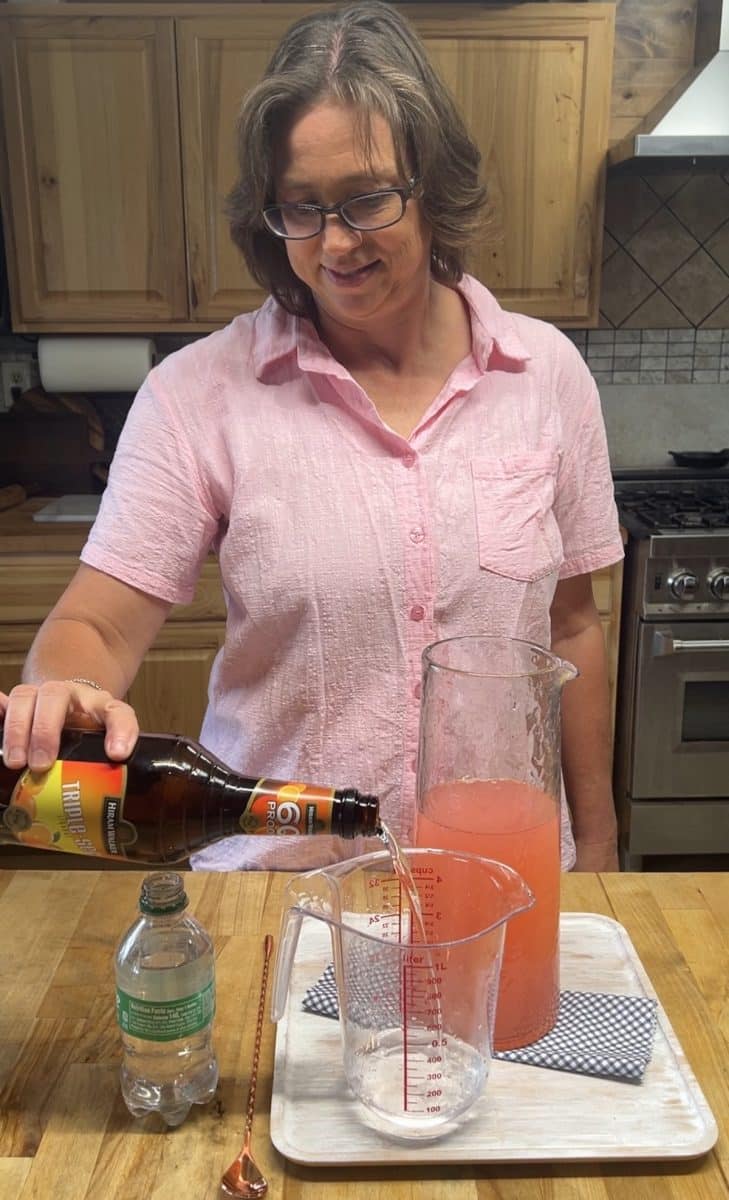 Pouring triple sec into a measuring cup.
