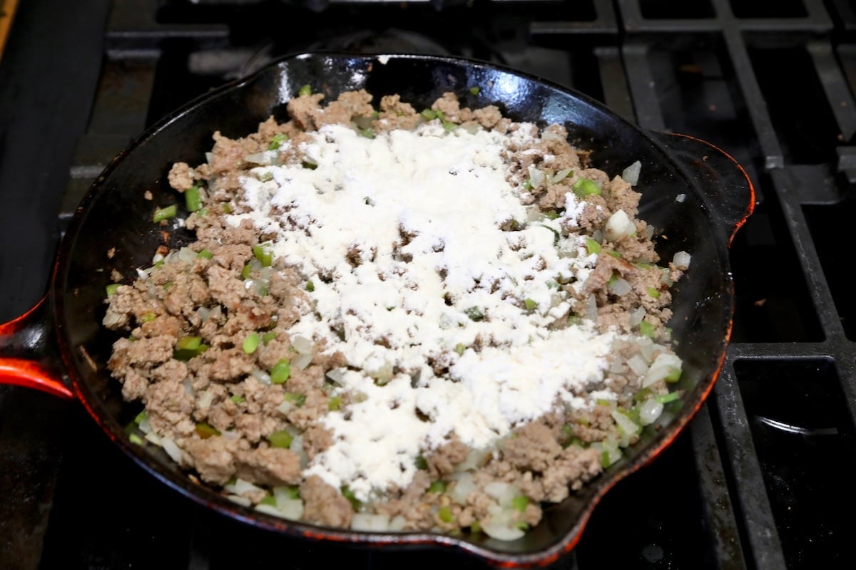 Adding flour to ground beef making sloppy joes.