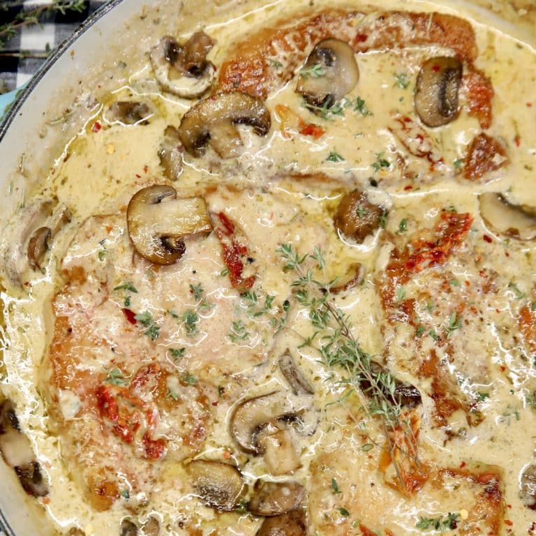 Pan of pork chops in creamy sauce.
