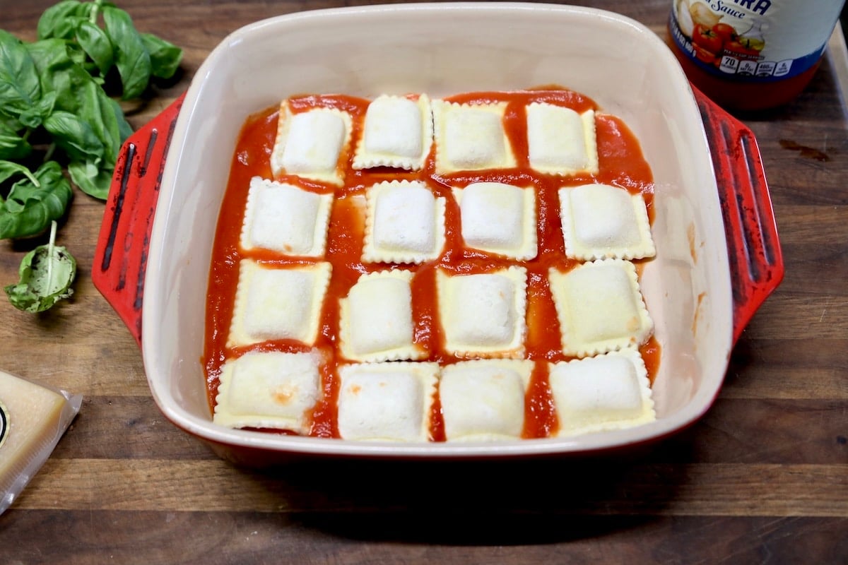 Frozen ravioli in a square casserole over marinara.
