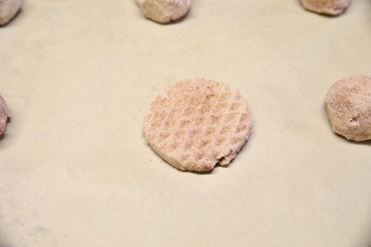 Stamped cookie dough on a baking sheet.