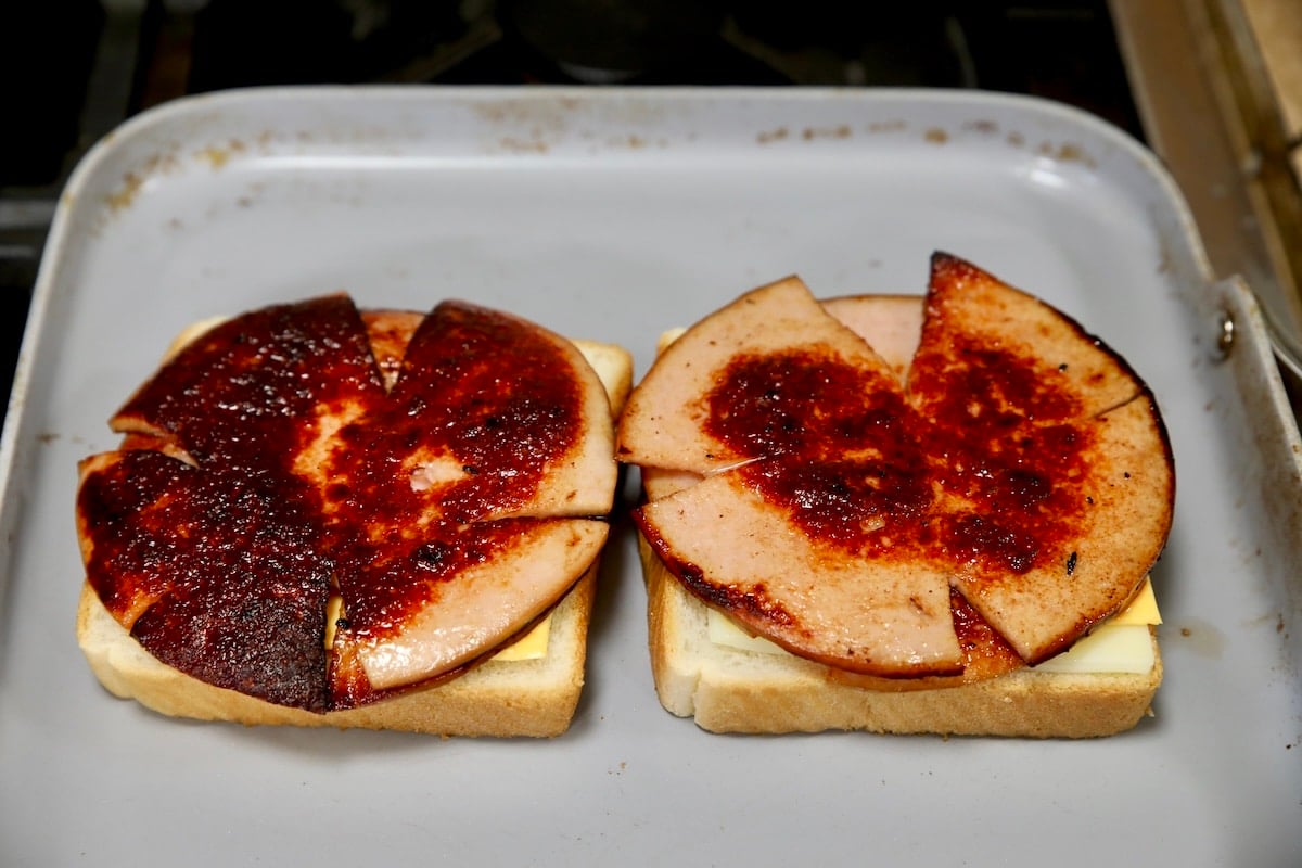 Making grilled cheese with fried bologna.
