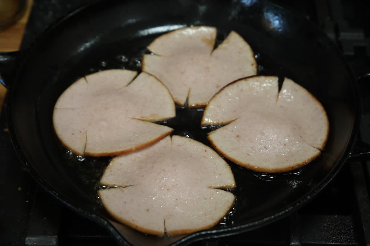 Frying bologna slices in a skillet.