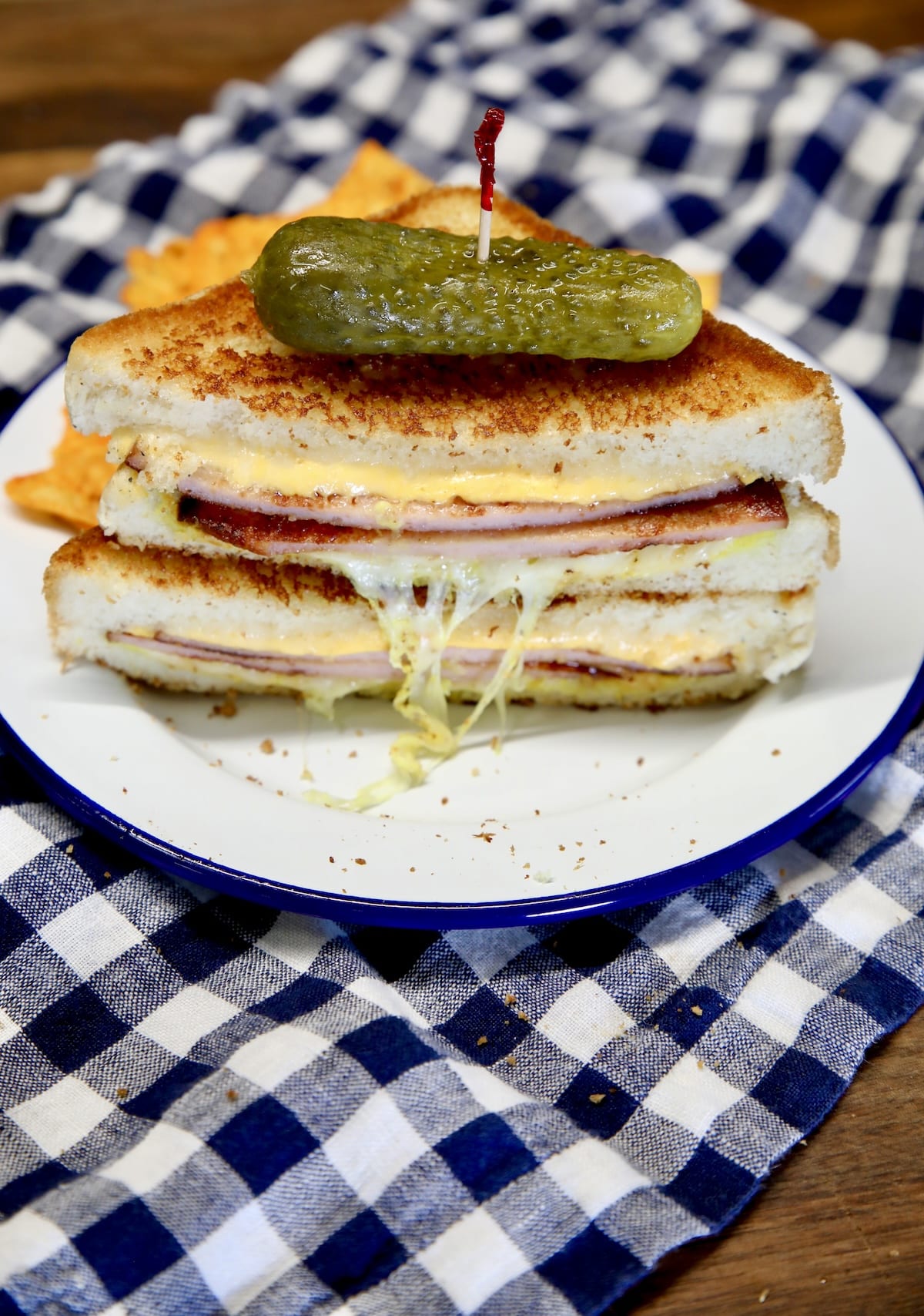Bologna grilled cheese cut in half and stacked with pickle on top.