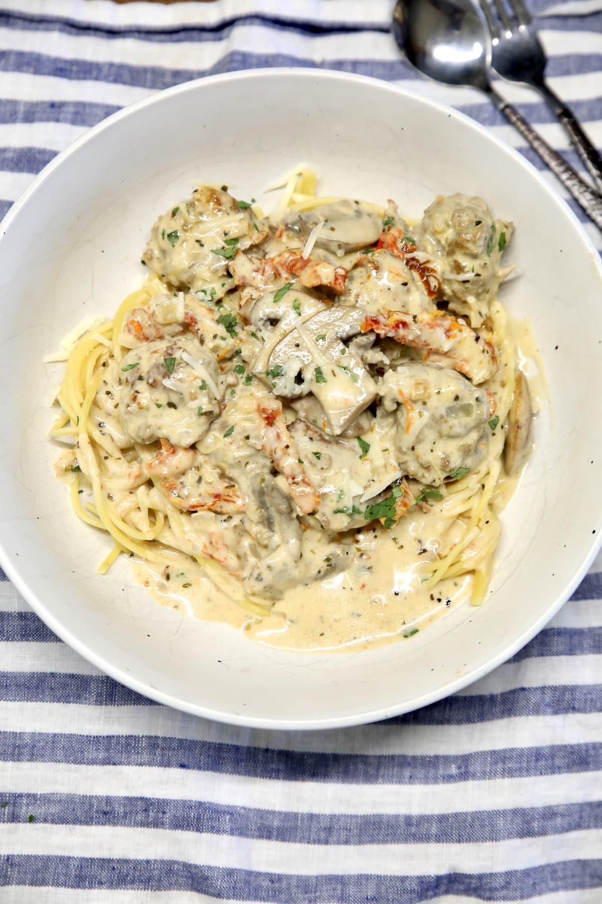 Bowl of spaghetti and meatballs with marry me creamy Italian sauce.