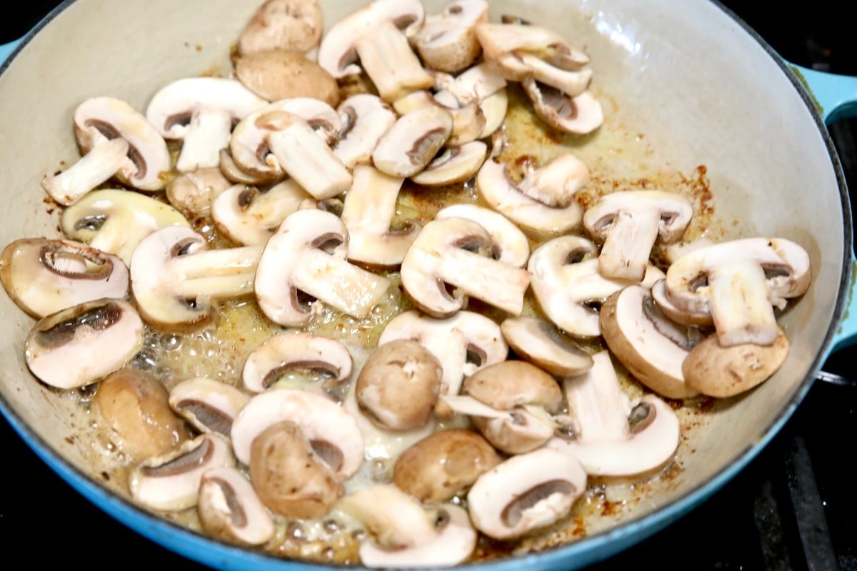 Sliced mushrooms in a skillet.