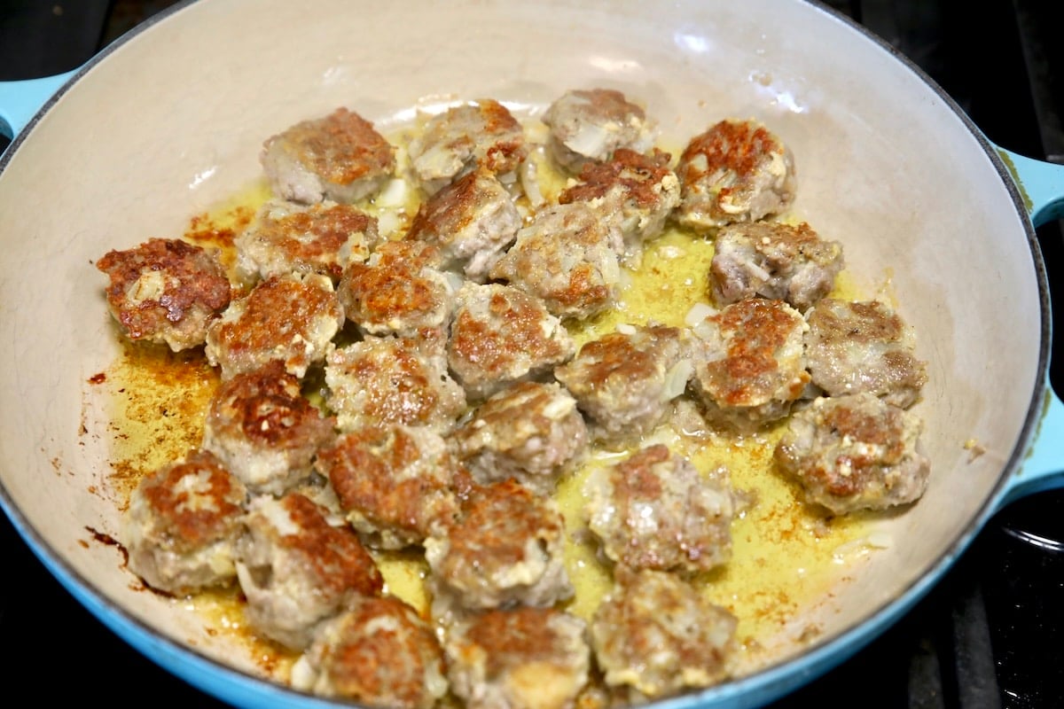 Browned meatballs in a skillet.