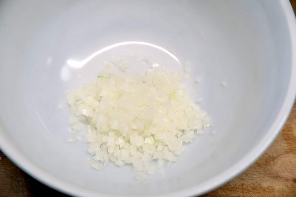 Diced onion in a bowl for meatballs.