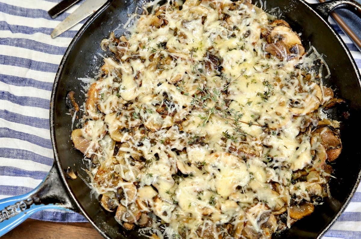 Pan of mushrooms with melted cheese.