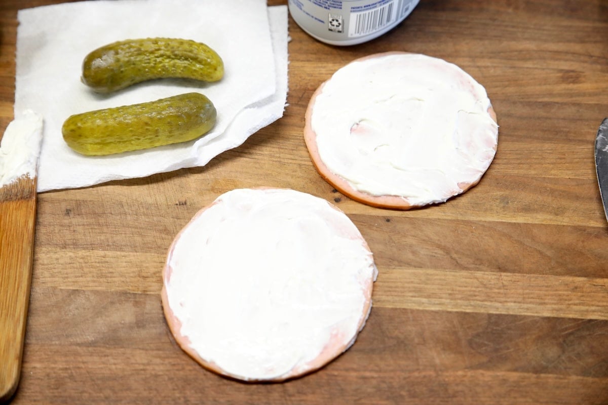 Cream cheese spread onto 2 slices of bologna.