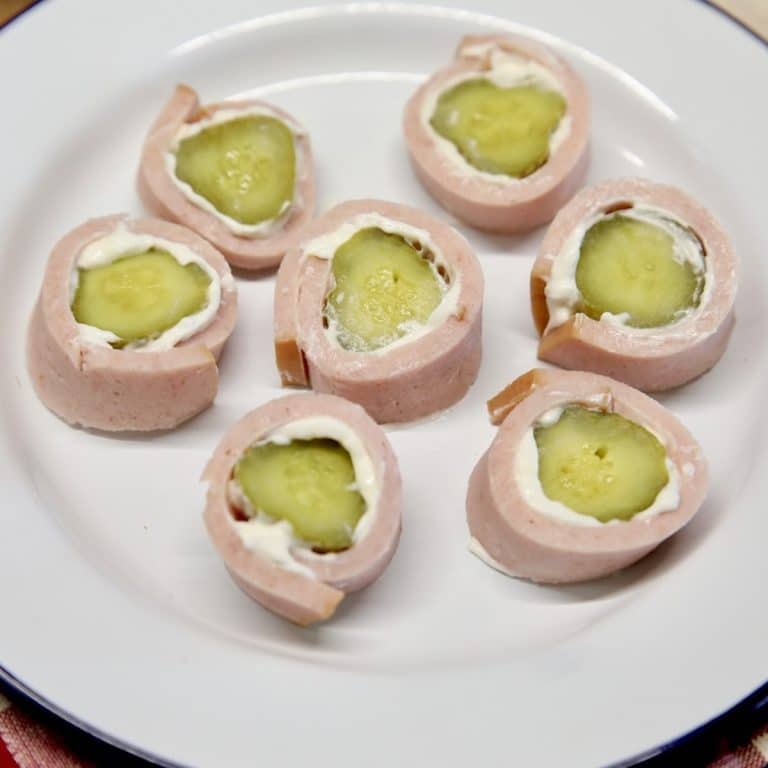 Bologna cream cheese pickle roll ups on a plate.