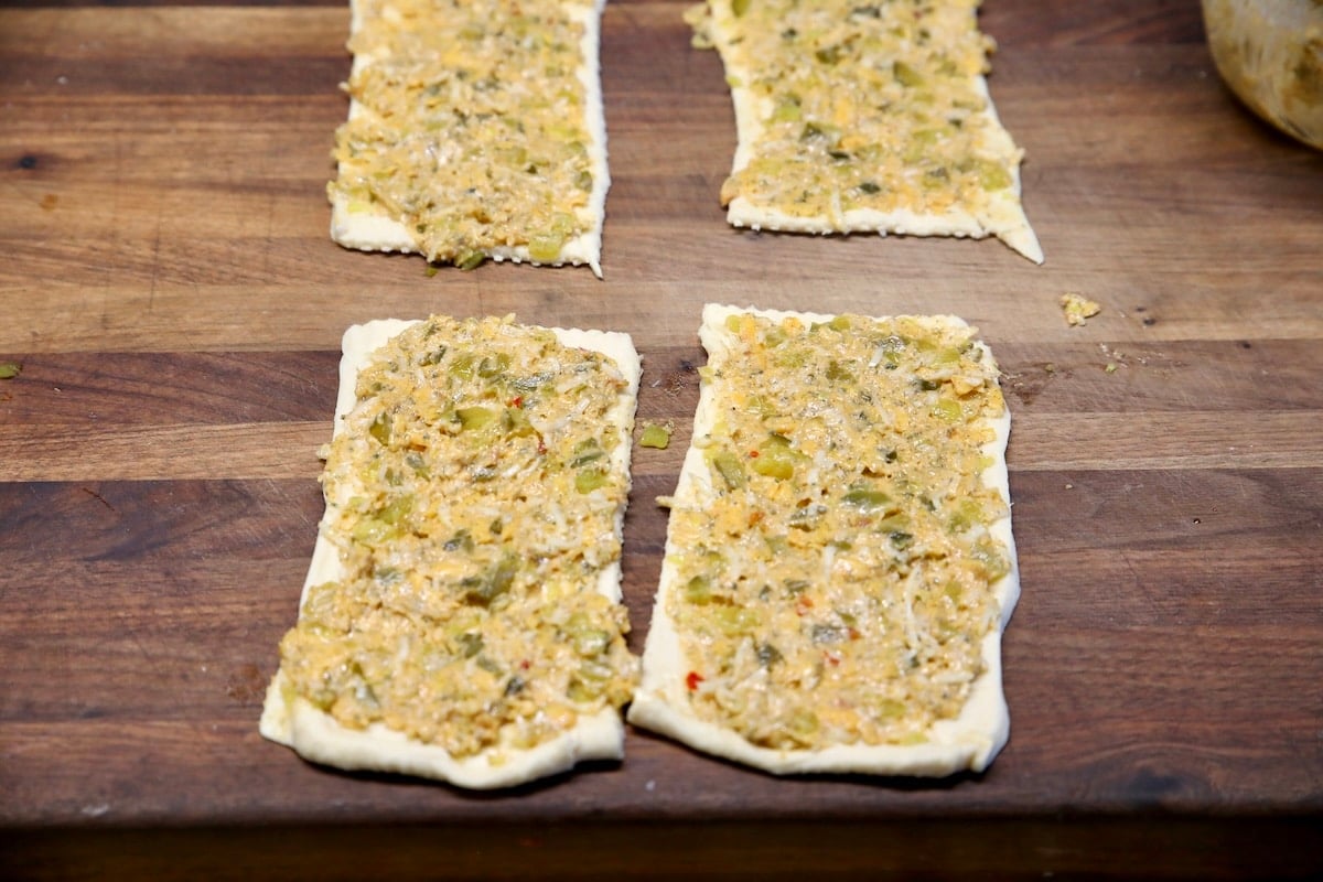 Cheesy pickle filling spread onto crescent dough.