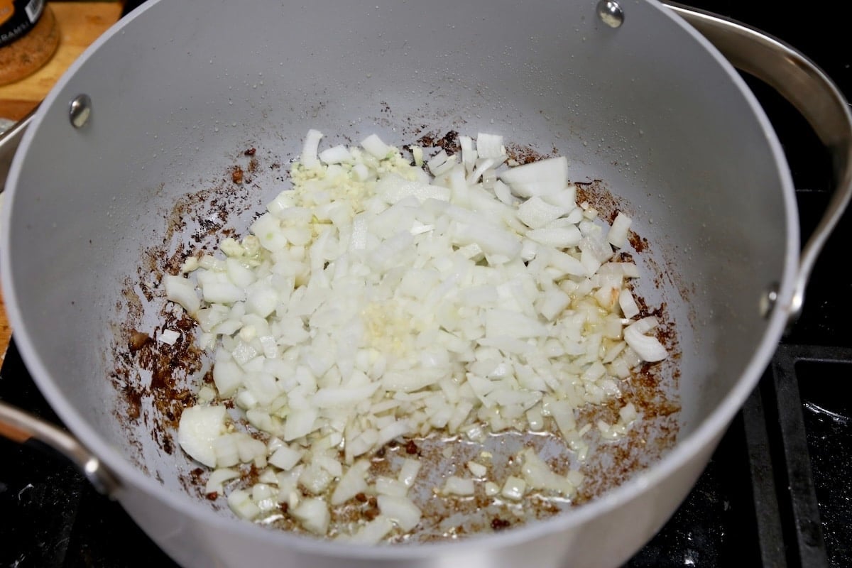 Cooking onions and garlic ini a pan for soup.