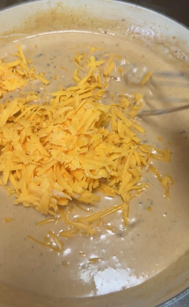 Adding cheese to pasta sauce.