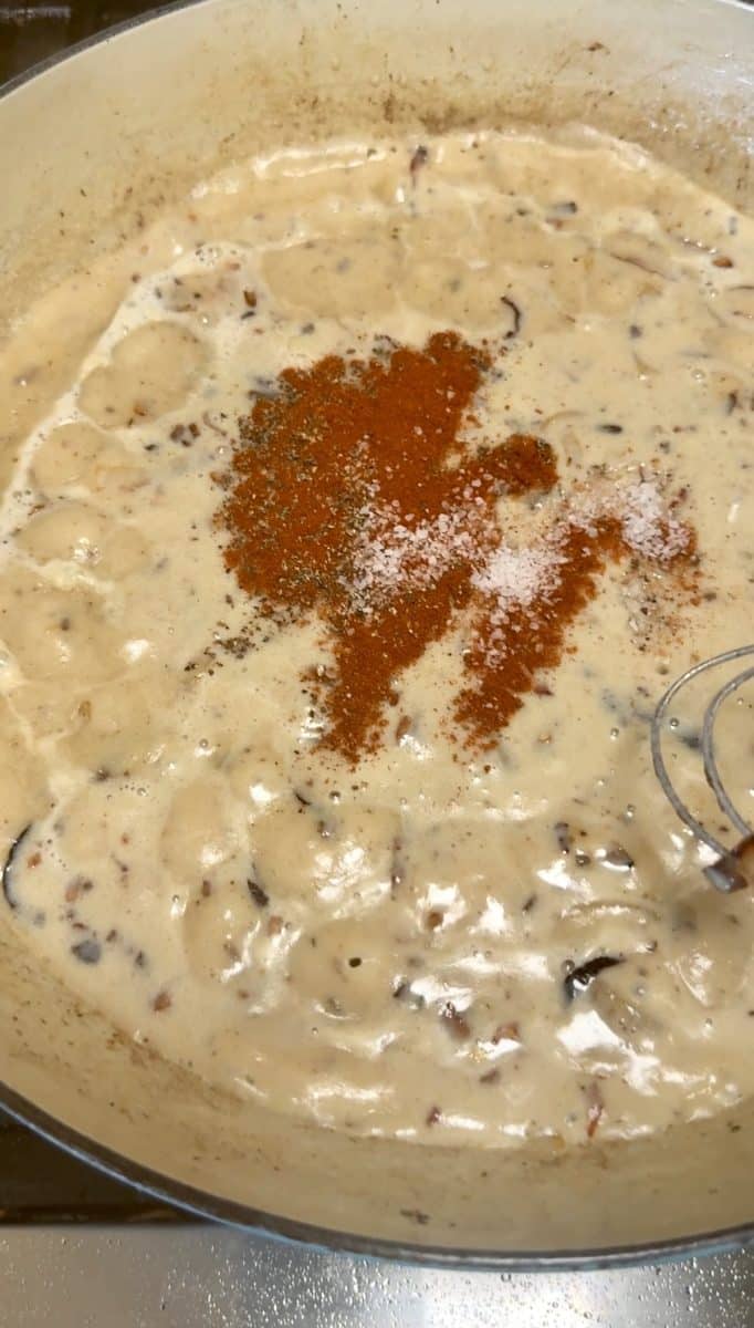 Seasoning cheese sauce in a skillet.