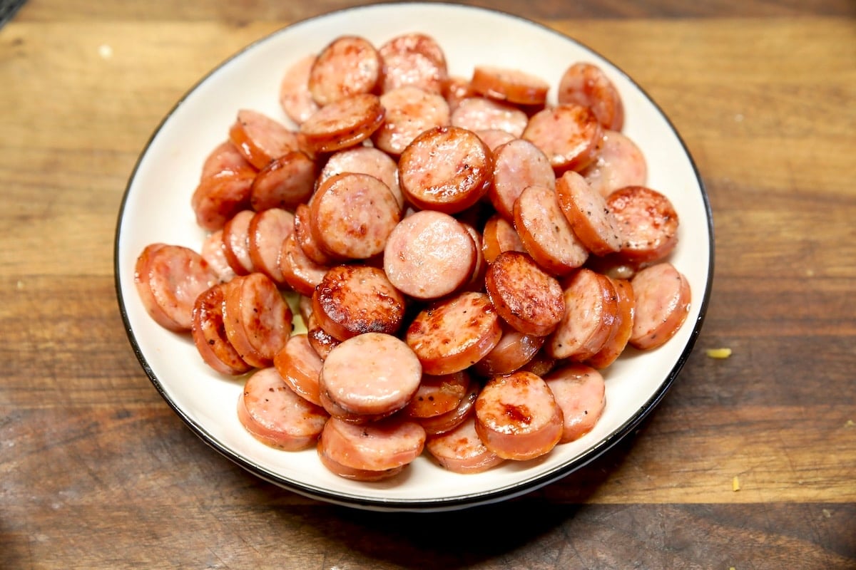 Sliced smoked sausage, browned in a bowl.