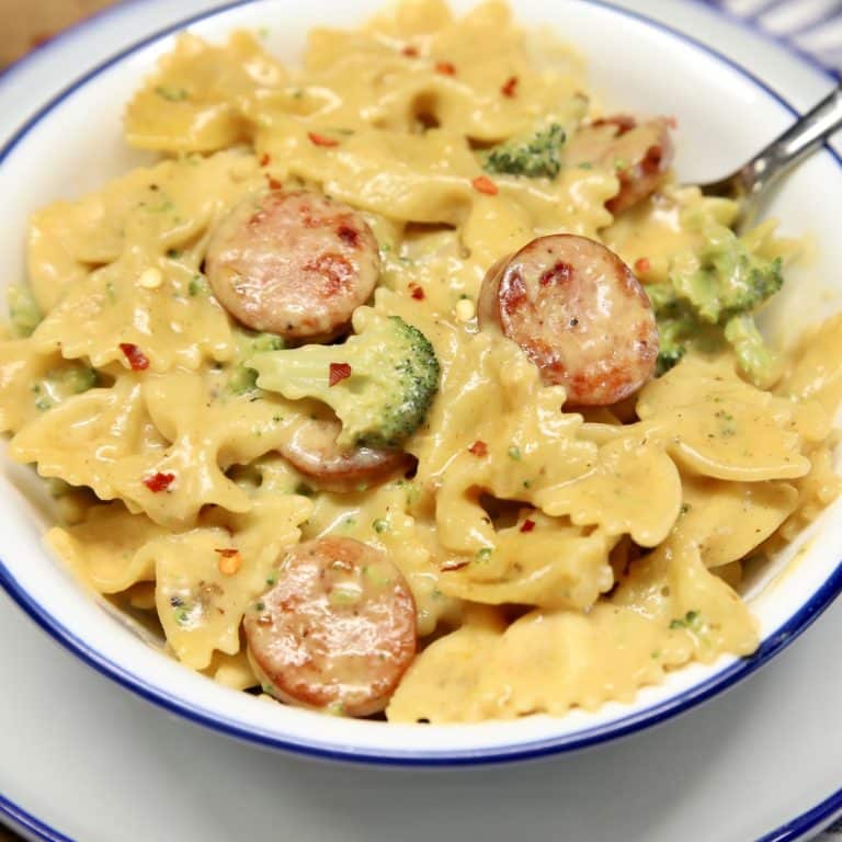 Smoked sausage pasta in a bowl with spoon.